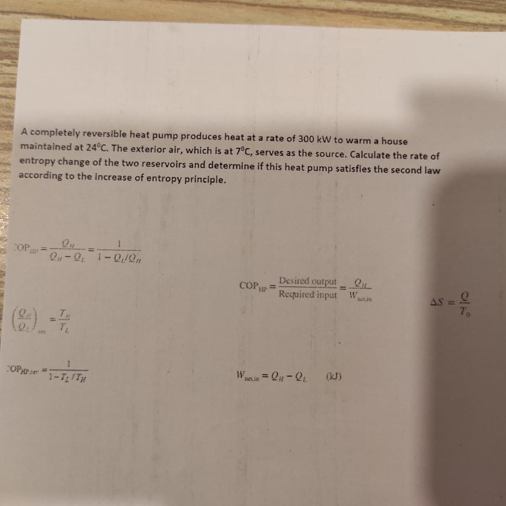 A completely reversible heat pump produces heat at a rate of \( 300 \mathrm{~kW} \) to warm a house maintained at \( 24^{\cir